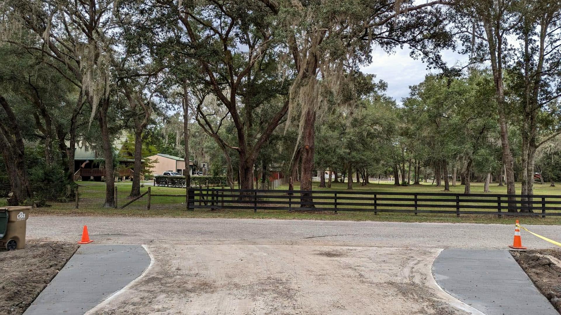 A finished limerock driveway and apron curving under live oaks